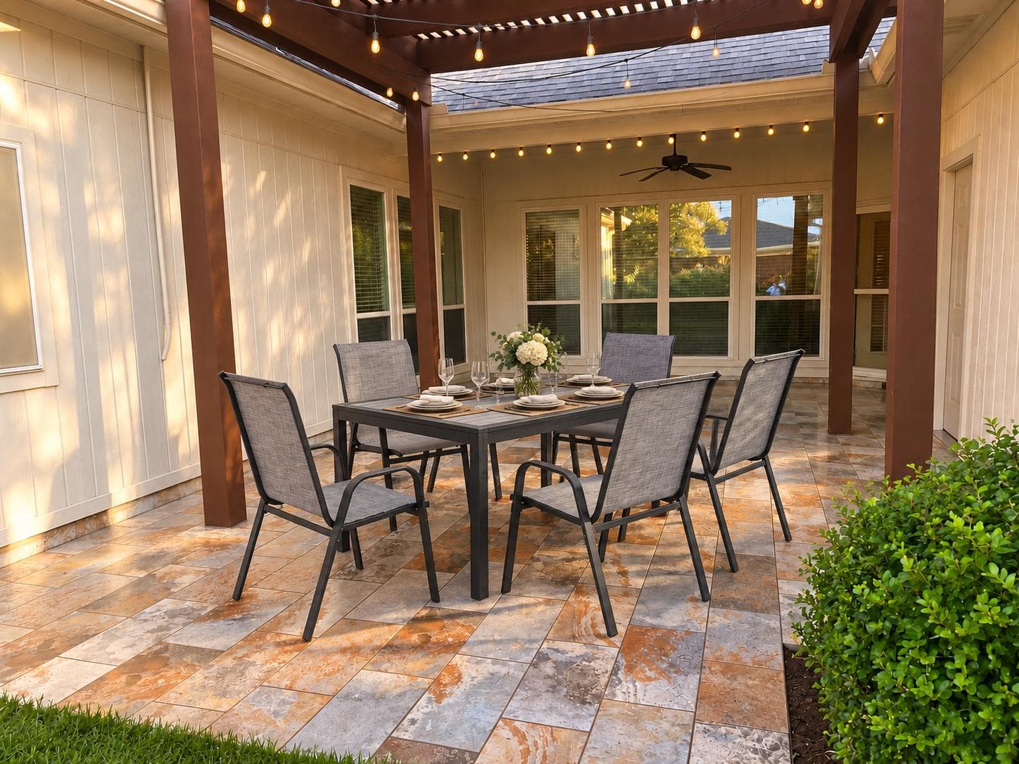 The covered patio, set for dining under string lights